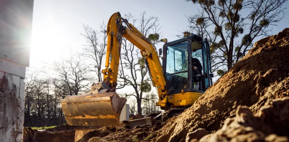 Mini excavator in a residential worksite demonstrating safe operation techniques.