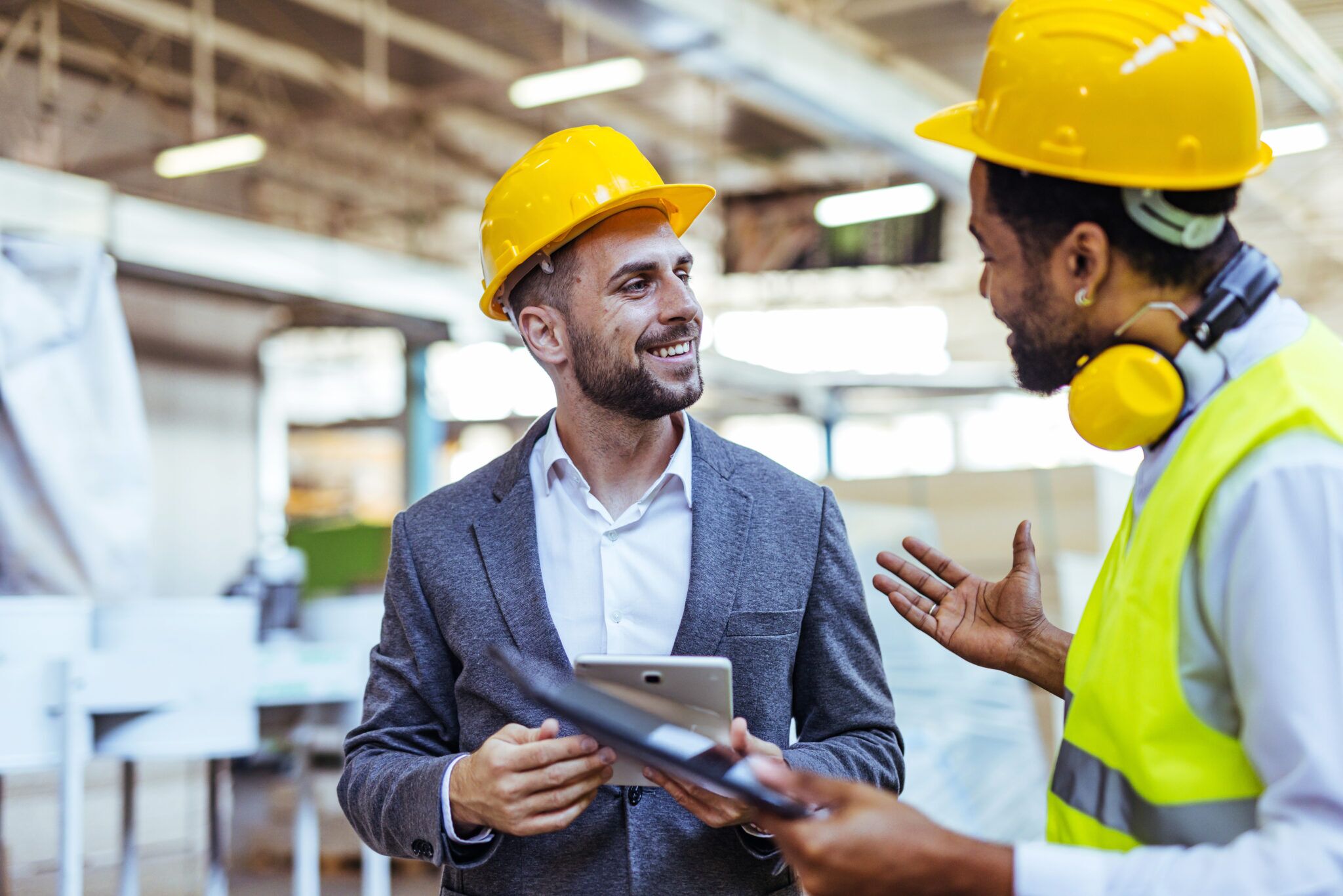 Two men wearing Hard-hats, discussing something