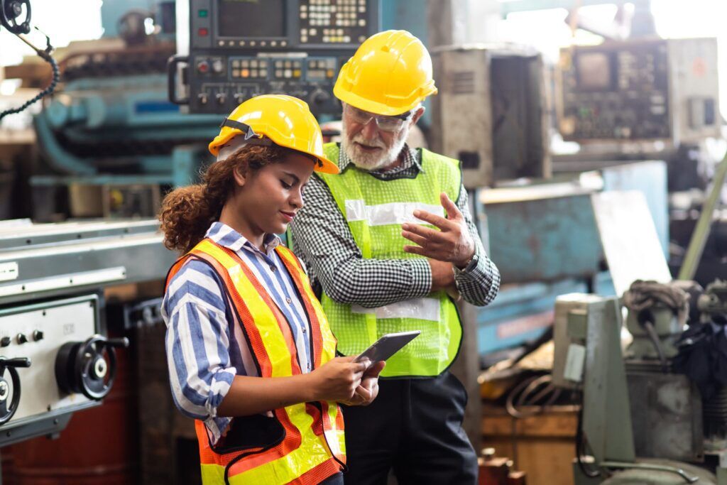 Professional Mechanical Engineer team Working on Personal Computer at Metal lathe industrial manufacturing factory.