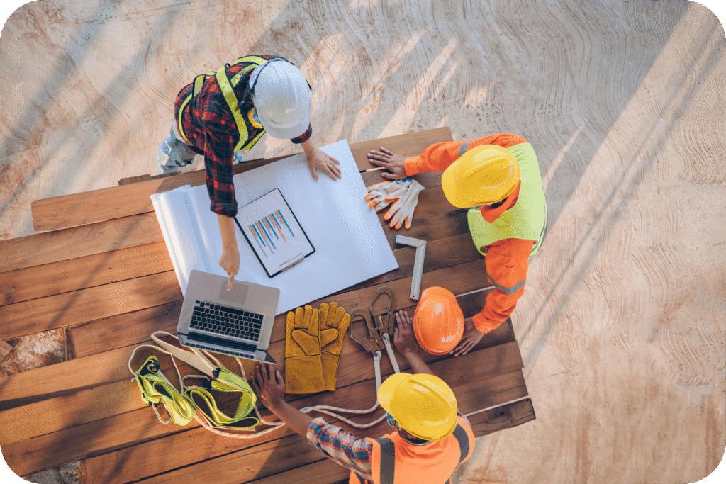 Construction team reviewing project plans on tablet at a building site.