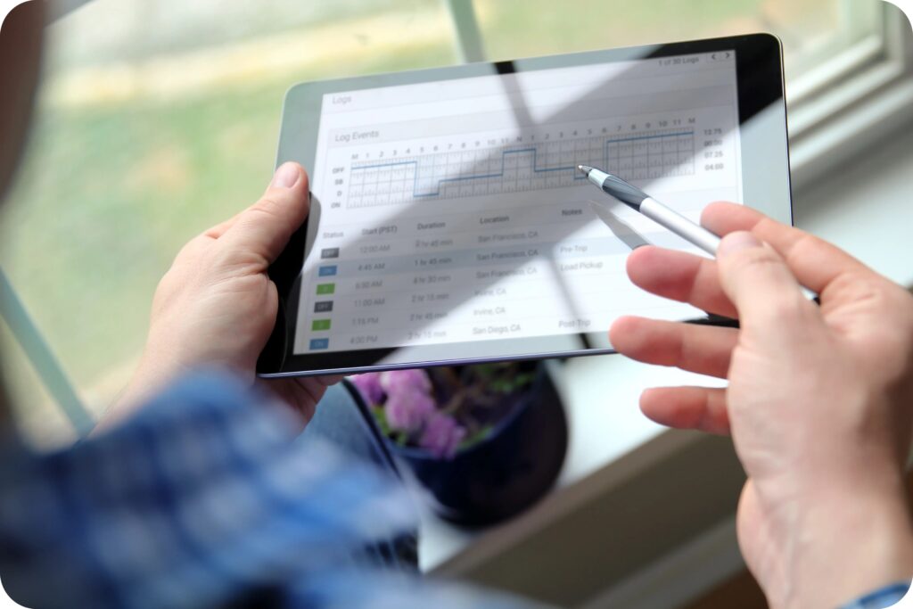 Individual checking digital duty-status records on a tablet for Canadian Hours of Service adherence.
