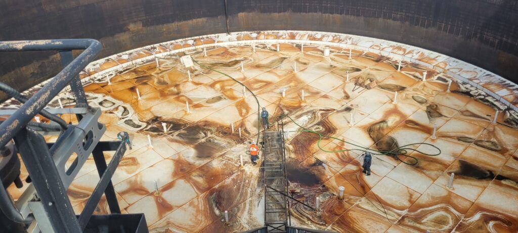 High-risk industrial tank cleaning environment where people-first safety leadership helps crews manage confined space and operational hazards.