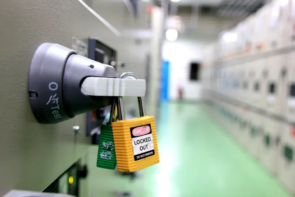 Lockout/tagout tag applied to a yellow industrial valve manifold during maintenance isolation.