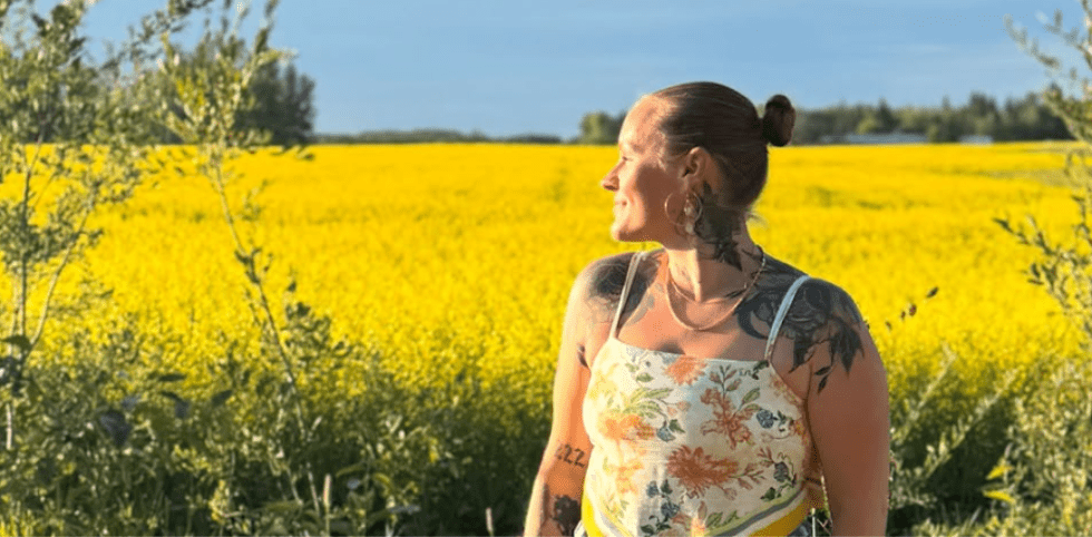Megan Scott in a yellow field at sunset, symbolizing her unconventional, worker‑focused safety path.