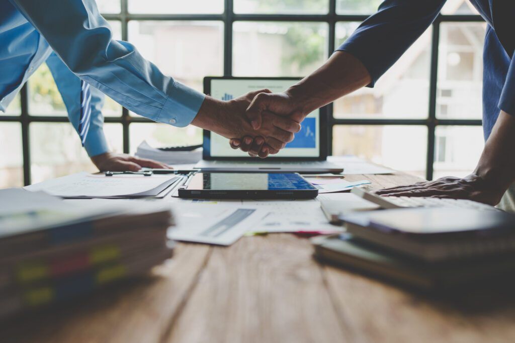 Young businessman and financial representative shaking hands after a budget deal for business expansion